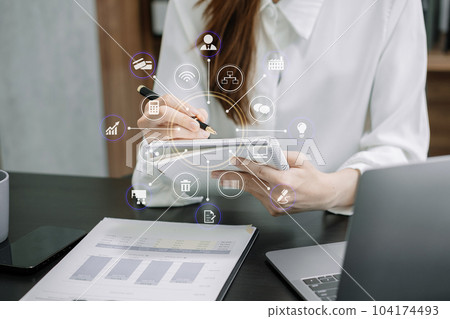 woman using laptop to work and writing on notebook with pen in office. 104174493
