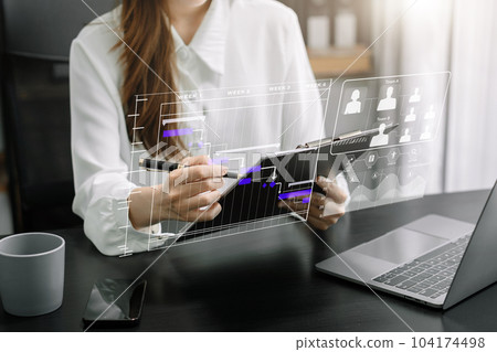 Business woman hand Project manager working and update tasks and Gantt chart scheduling virtual diagram.with smart phone, tablet and laptop in office. Business woman hand Project manager working and update tasks and Gantt chart scheduling virtual diagram.with smart phone, tablet and laptop in office. 104174498