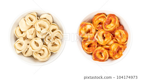 Tortellini in white bowls. Industrially made stuffed dumplings, Italian pasta with distinctive shape, also called belly buttons. Uncooked and dried pasta (left), and boiled, with tomato sauce (right). Tortellini in white bowls. Industrially made stuffed dumplings, Italian pasta with distinctive shape, also called belly buttons. Uncooked and dried pasta (left), and boiled, with tomato sauce (right). 104174973