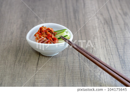 Kimchi and shredded cucumber served on a small white plate 104175645