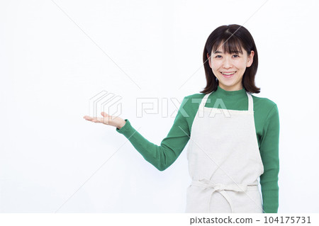 一位三十多歲的家庭主婦，穿著圍裙，在白人背景前介紹 104175731