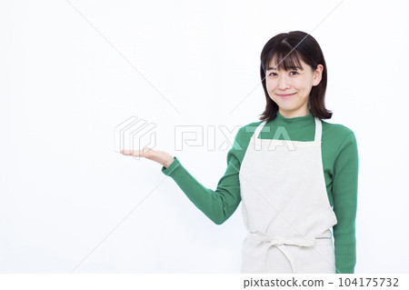 一位三十多歲的家庭主婦，穿著圍裙，在白人背景前介紹 104175732