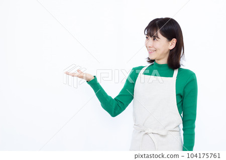 一位三十多歲的家庭主婦，穿著圍裙，在白人背景前介紹 104175761