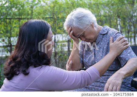 Asian elderly woman headache while sitting on wheelchair at park, healthy strong medical concept. 104175984