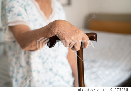 Asian elderly disability woman holding waling stick, wood cane, round handle, walking aid for help to walk. Asian elderly disability woman holding waling stick, wood cane, round handle, walking aid for help to walk. 104175986