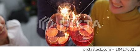 Group of happy people enjoying fireworks party in cocktail glasses Group of happy people enjoying fireworks party in cocktail glasses 104176323