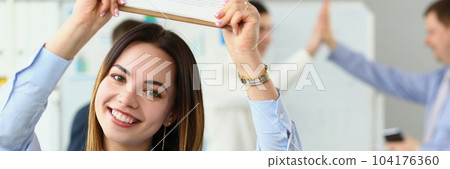 Portrait of smiling beautiful businesswoman holding clipboard with financial charts in background successful team Portrait of smiling beautiful businesswoman holding clipboard with financial charts in background successful team 104176360