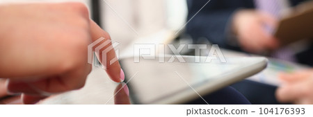 Woman holds tablet in hands and explains information to colleague Woman holds tablet in hands and explains information to colleague 104176393