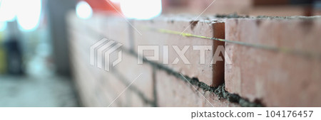 Brickwork of the wall correct laying of red brick for reliable wall of strong house or brick building 104176457