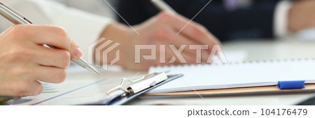 Group of business people sitting at table with tablets and pens taking notes closeup Group of business people sitting at table with tablets and pens taking notes closeup 104176479
