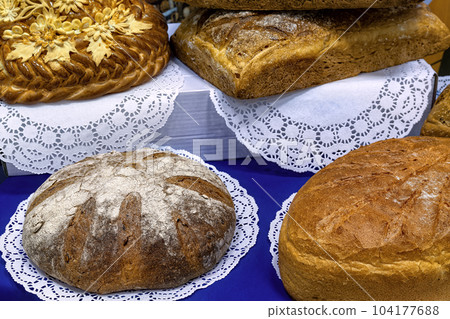 Various traditional handmade breads on the racks in the bakery. Bread background. 104177688