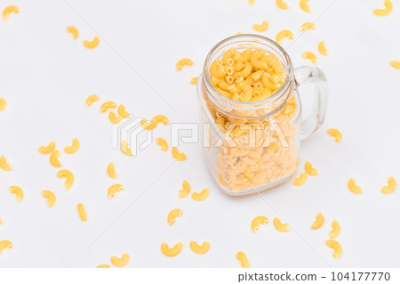 Uncooked Chifferi Rigati Pasta in Glass Jar on White Background Uncooked Chifferi Rigati Pasta in Glass Jar on White Background 104177770