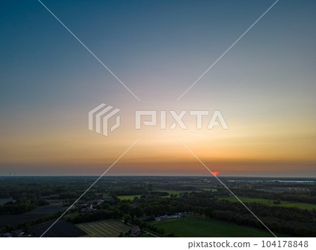 Aerial view of endless lush pastures and farmlands of Belgium under a colorful and dramatic sunset Aerial view of endless lush pastures and farmlands of Belgium under a colorful and dramatic sunset 104178848