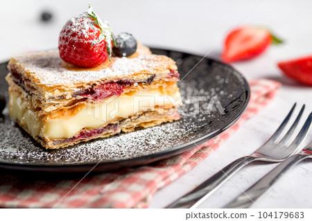 A piece of Napoleon cake with poppy seeds and cherries A piece of Napoleon cake with poppy seeds and cherries 104179683