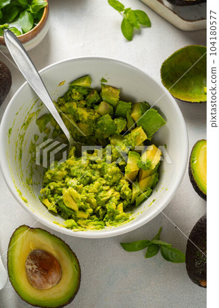 Guacamole in a bowl, cooking homemade avocado mash dip. Guacamole in a bowl, cooking homemade avocado mash dip. 104180577