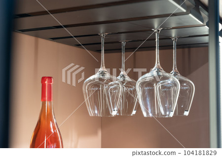 Empty wine glasses hanging on a stand kitchen furniture 104181829