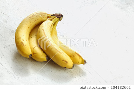 Bunch of ripe bananas on white working board. Bunch of ripe bananas on white working board. 104182601