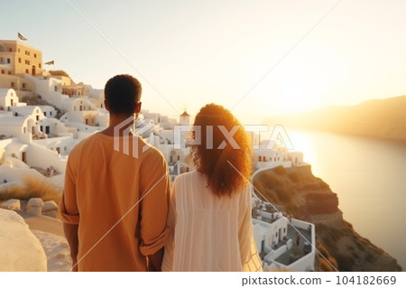 Beautiful young woman and man on their summer vacation walk on greek island Santorini 104182669
