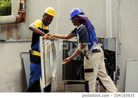 Proficient workers taking apart hvac system panel with industry techniques and professional equipment to recondition refrigerant tank, electrical system issues and frozen evaporator coils Proficient workers taking apart hvac system panel with industry techniques and professional equipment to recondition refrigerant tank, electrical system issues and frozen evaporator coils 104183635