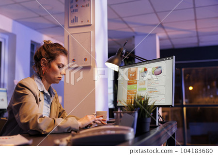 Tired businesswoman sitting at desk late at night in startup office. working overhours at company strategy. Exhausted executive manager analyzing marketing graphs report, typing profit progress Tired businesswoman sitting at desk late at night in startup office. working overhours at company strategy. Exhausted executive manager analyzing marketing graphs report, typing profit progress 104183680