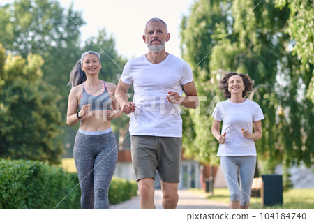 Mature friends running together outdoor, jogging. Mature friends running together outdoor, jogging. 104184740