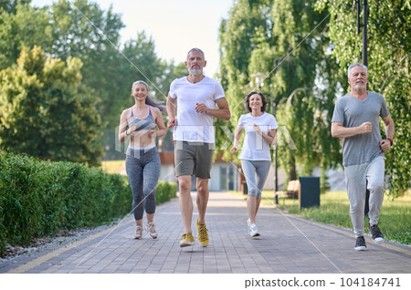 People jogging in park, enjoying friend time at jogging park while running. People jogging in park, enjoying friend time at jogging park while running. 104184741