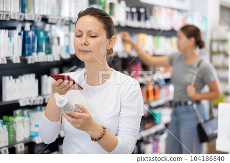 Adult woman looking for cosmetic product from photo on internet Adult woman looking for cosmetic product from photo on internet 104186840