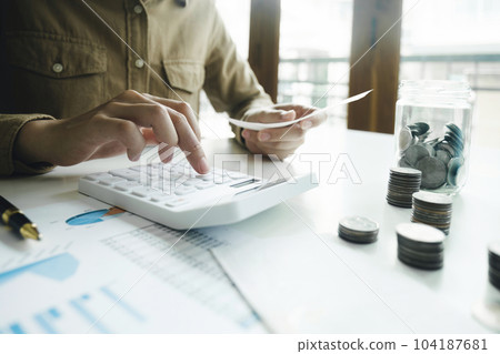 Accountant using calculator for calculate finance report in office 104187681