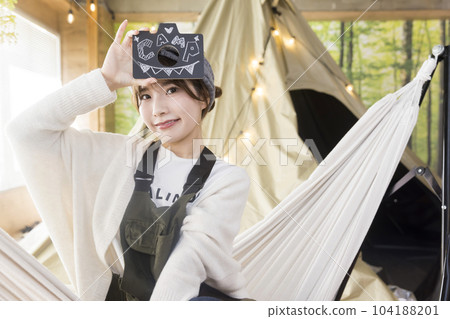 A young woman sitting in a hammock and showing letters Home camping Home camping Camping image 104188201