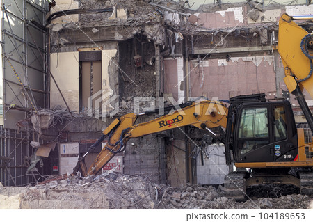 Yumbo and a collapsing wall at a building demolition site Yumbo and a collapsing wall at a building demolition site 104189653