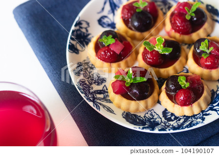 Bite tart topped with frozen berries 104190107