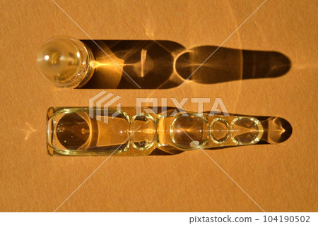 Glass ampoules on a beige orange background. 104190502