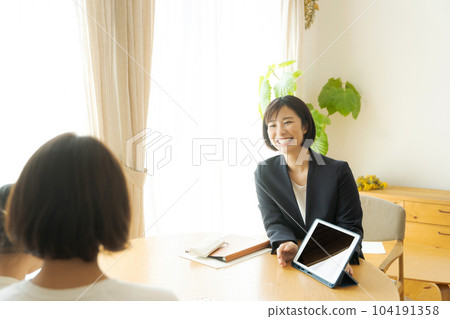 A woman in a suit having a conversation with her parent and child 104191358