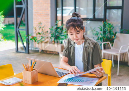 Freelance worker working on documents with graphs. and information about finances on laptops in cafes 104191553