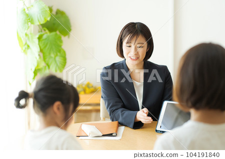 Photo of a woman in a suit talking to her parents Photo of a woman in a suit talking to her parents 104191840