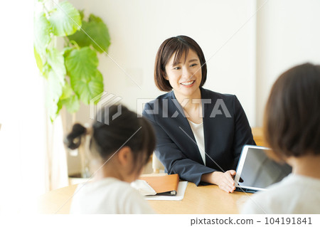 一個穿西裝的女人和她的父母交談的照片 一個穿西裝的女人和她的父母交談的照片 104191841