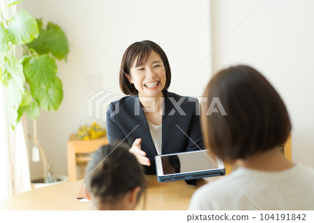 一個穿西裝的女人和她的父母交談的照片 104191842