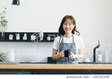 一名婦女飲用的咖啡在廚房裡 104192599