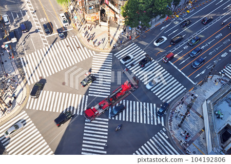 A red vehicle passing through the Ginza Scramble Crossing 104192806