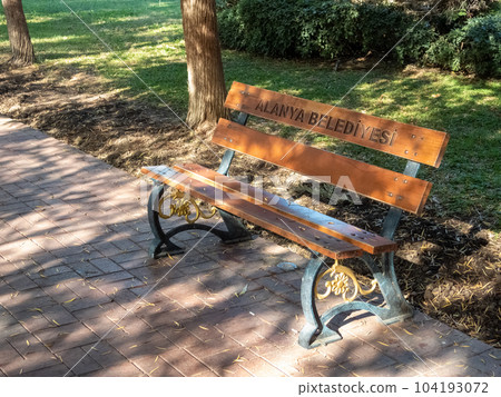 Alanya, Turkey - Nov 3, 2022. Bench in a city park, in patches of sunlight Alanya, Turkey - Nov 3, 2022. Bench in a city park, in patches of sunlight 104193072