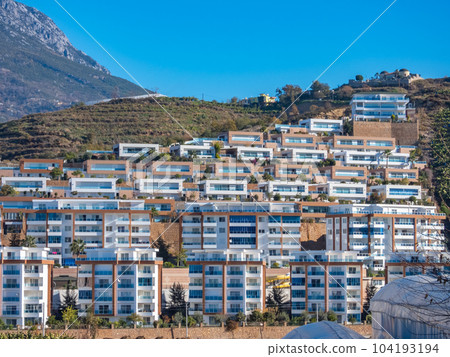 Alanya, Turkey - Jan 4, 2023. Modern residential buildings on a hillside against the backdrop of the Taurus Mountains 104193194