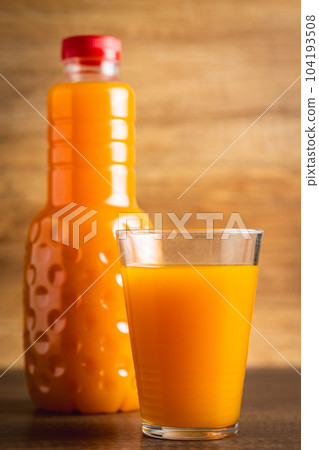 A glass of fruit juice. Orange juice on wooden table. A glass of fruit juice. Orange juice on wooden table. 104193508