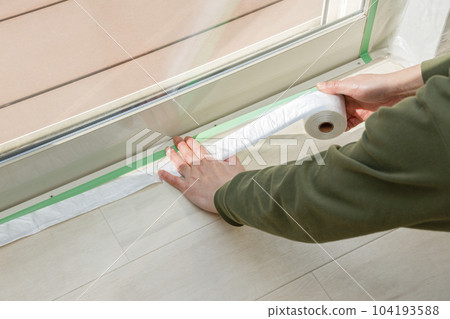 一名男子在貼窗玻璃貼膜前戴口罩防止漏水 104193588