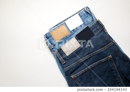 Two pairs of denim trousers with an empty leather label . Two pairs of denim trousers with an empty leather label . 104194143