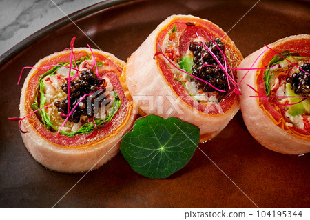 Sushi rolls with tuna, omelette, avocado, orange, caviar in mamenorii 104195344