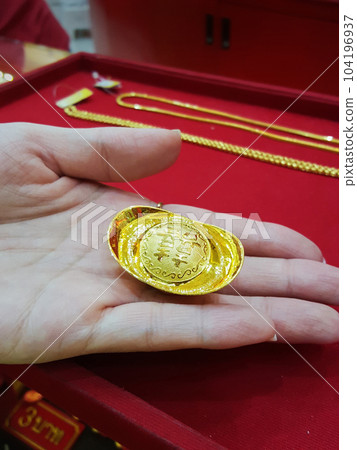 Closeup chinese gold nugget on hand 104196937