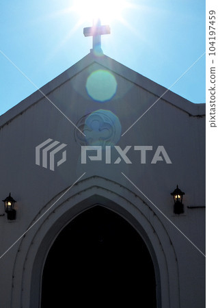教堂屋頂上的十字架被陽光照亮 教堂屋頂上的十字架被陽光照亮 104197459