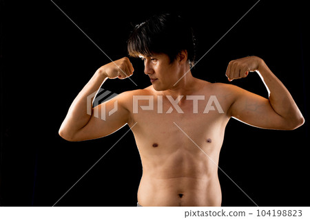 Young confident Asian man shirtless posing rising two arms muscle 104198823