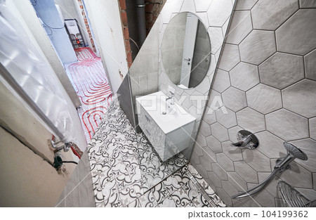 Photo collage of apartment bathroom before and after restoration. Comparison of old room with underfloor heating pipes and new renovated restroom with sink, shower, mirror and towel dryer. 104199362