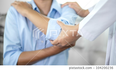 Female physiotherapists provide assistance to male patients with elbow injuries and examine patients in rehabilitation centers. Physiotherapy concepts 104200236